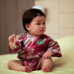 Japanese-Baby-Girl-Sitting-on-Bed