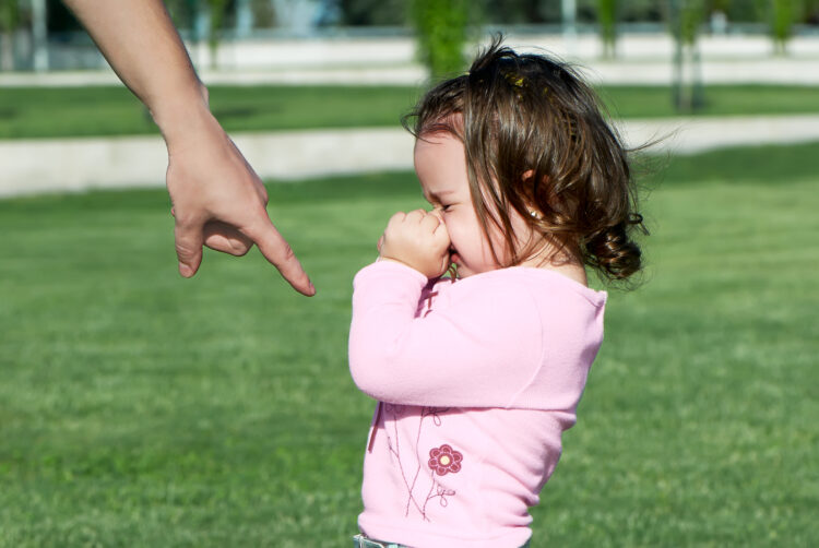father punishes a small daughter in the park