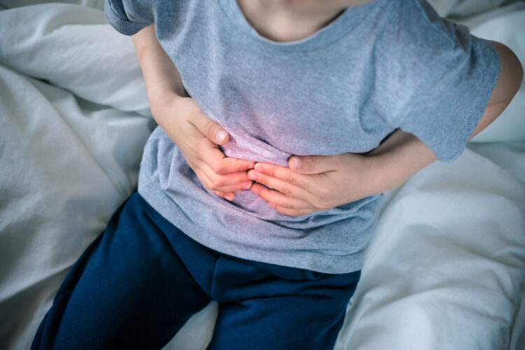 abdominal pain in a preschool child. poisoning in children. the boy holds his hands to the abdominal cavity